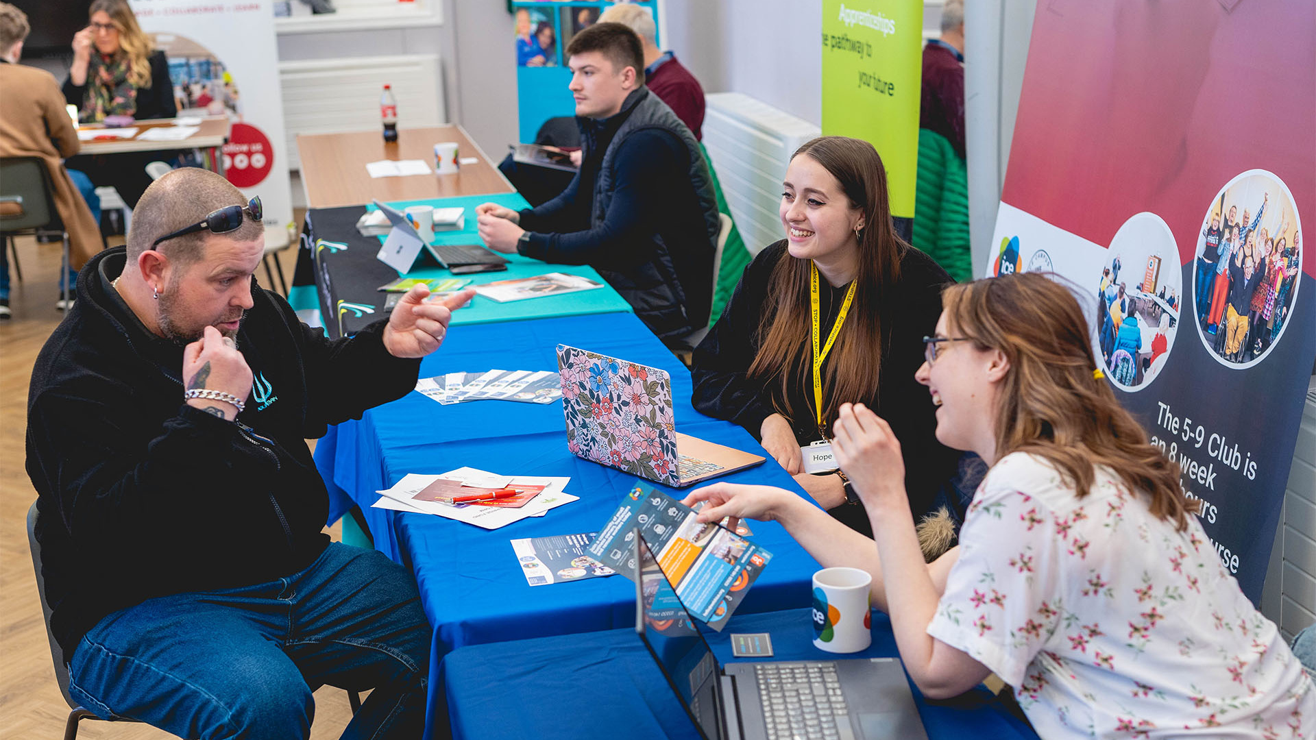 Man talking to Welsh ICE at a Business Support Fair demonstrating the coworking community in action
